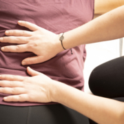 Claudia Sontheimer fühlt mit Händen Rückenverspannungen im unteren Rücken