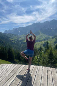 Claudia Sontheimer in den Bergen in der Asana Baum. 