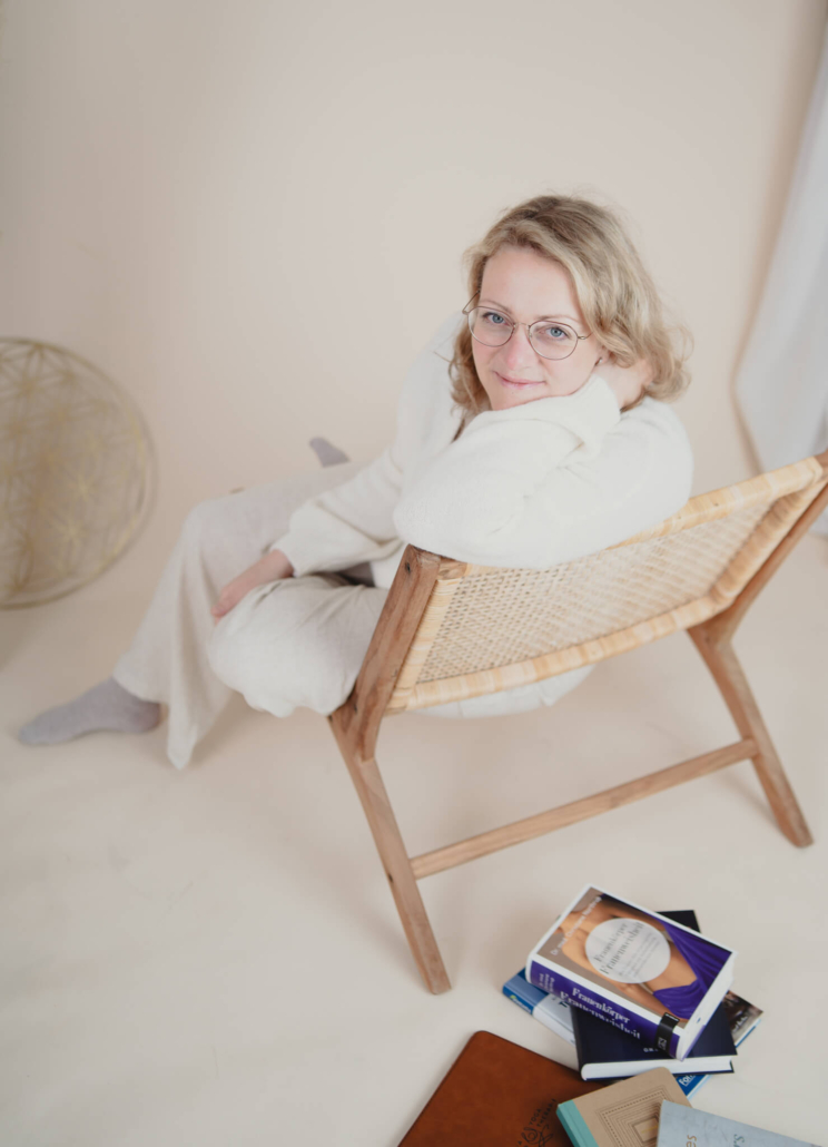 Claudia Sontheimer sitzt entspannt auf einem Holzstuhl, Heilpraktikerin und Yoga-Lehrerin Claudia Sontheimer sitzt entspannt auf einem Holzstuhl, Heilpraktikerin und Yoga-Lehrerin