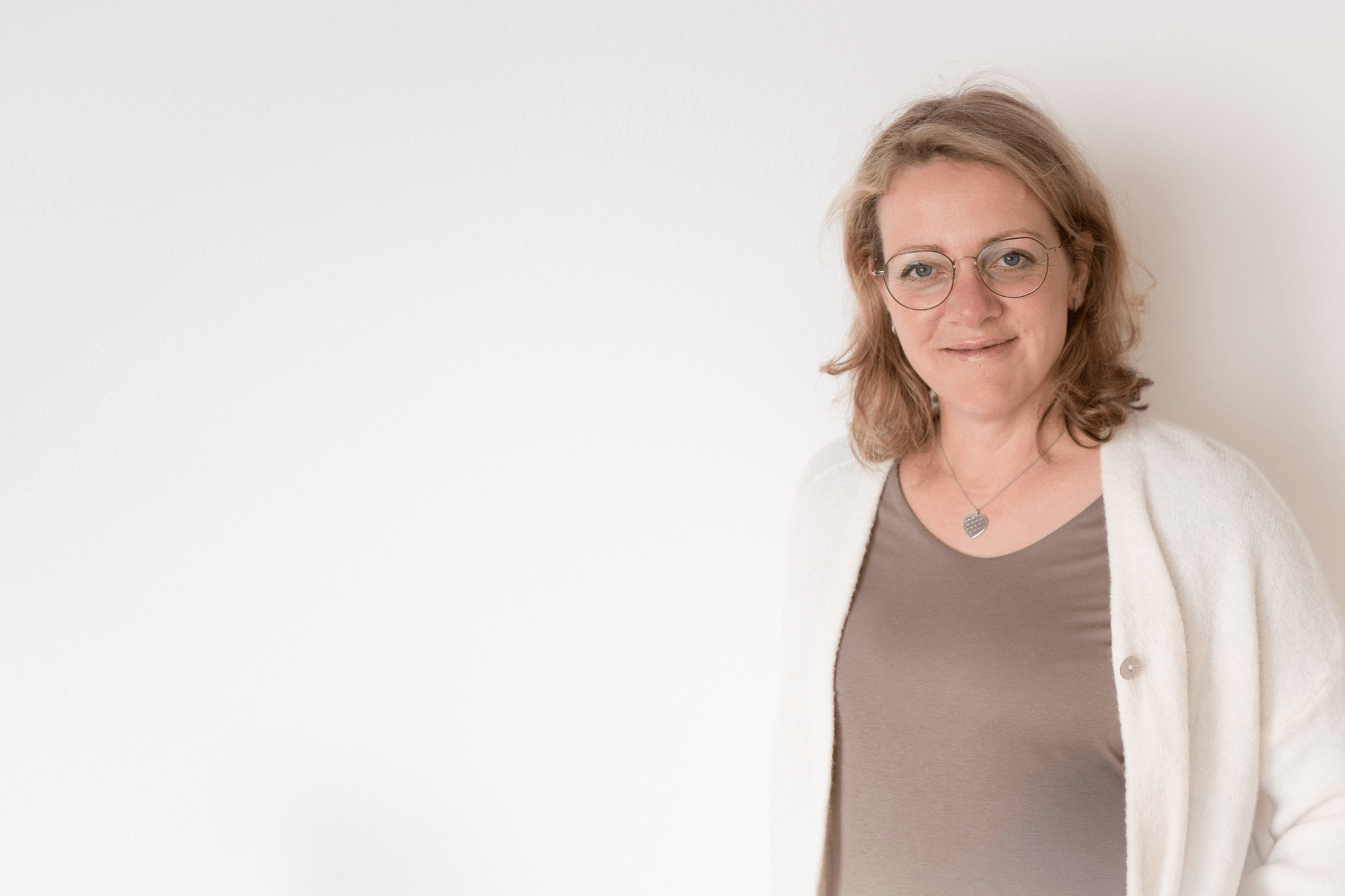 Claudia lächelt vor weißer Wand Claudia lächelt vor weißer Wand